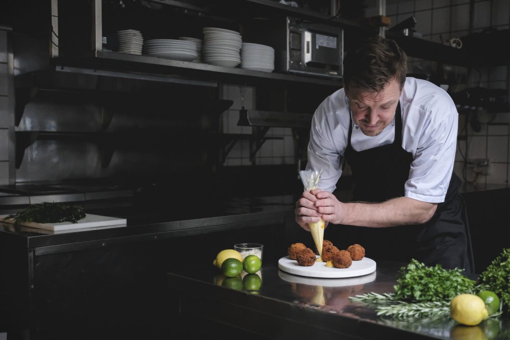 ordnungs frokostleverandør Jesper Kabbelgaard i gang med at anrette mad i køkkenet